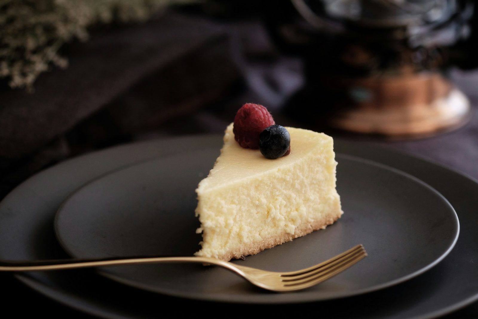 Cheesecake, sliced of cake on black plate