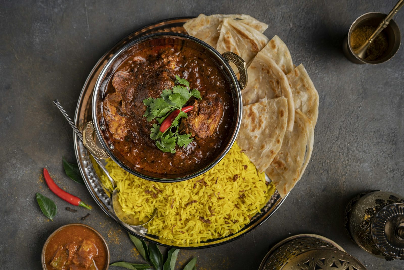 Trinidadian Curry Chicken or Goat, a bowl of curry, rice and pita bread
