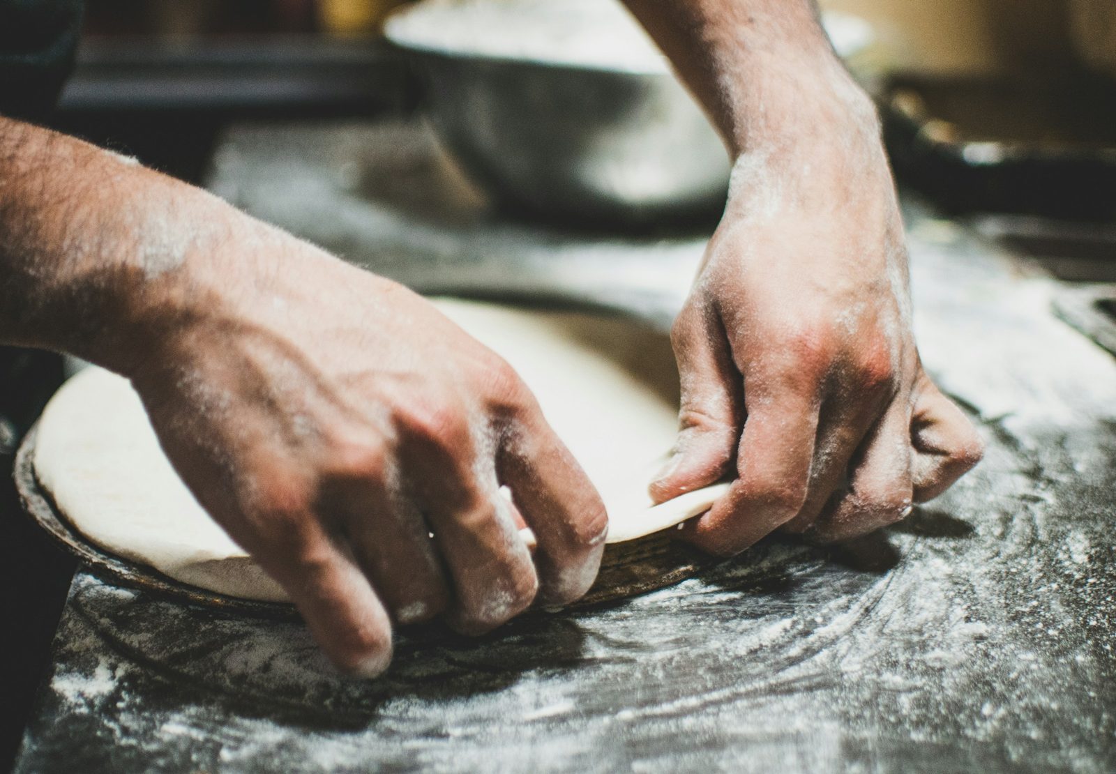 How to make pizza dough, a person is kneading dough on a table