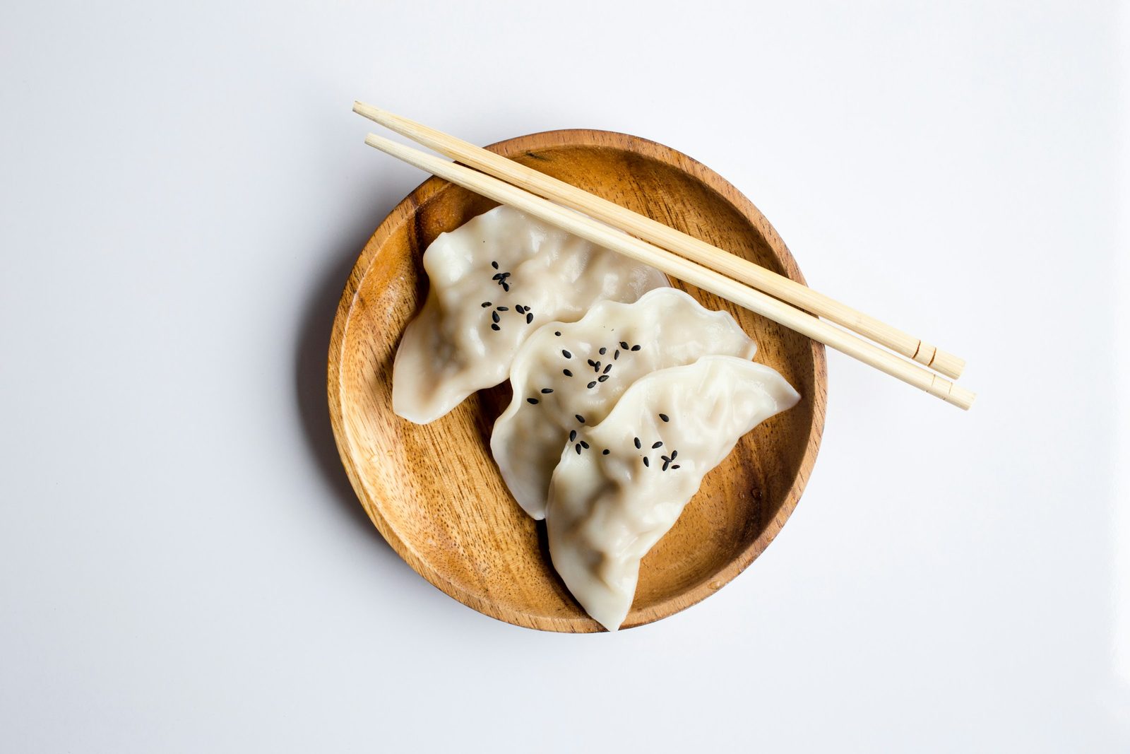 Chinese Wontons, three white dimsum on brown bowl
